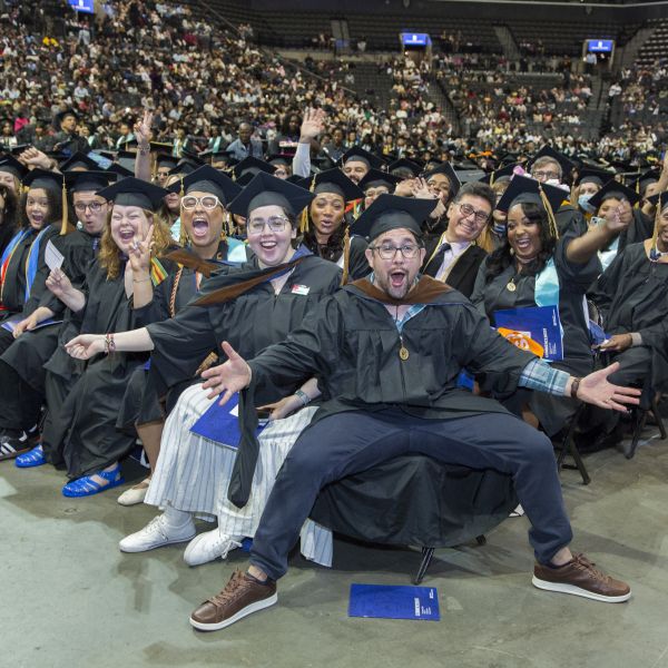 CUNY SPS Class of 2025 Commencement Group of Graduates Waving Hands Toward Camera