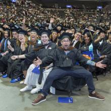 CUNY SPS Class of 2025 Commencement Group of Graduates Waving Hands Toward Camera