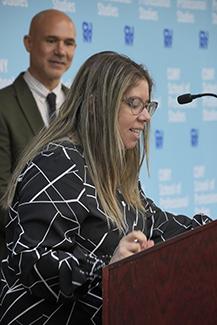 CUNY SPS student leader Lourdes Quinteros at the podium giving a speech