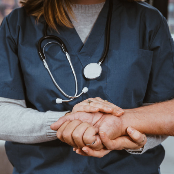 Photo of nurse clutching hand of a patient
