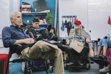 Lecturer sitting in classroom with people with disabilities