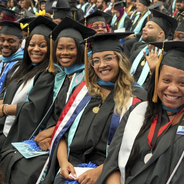 A smiling group of grads from the CUNY SPS Class of '24