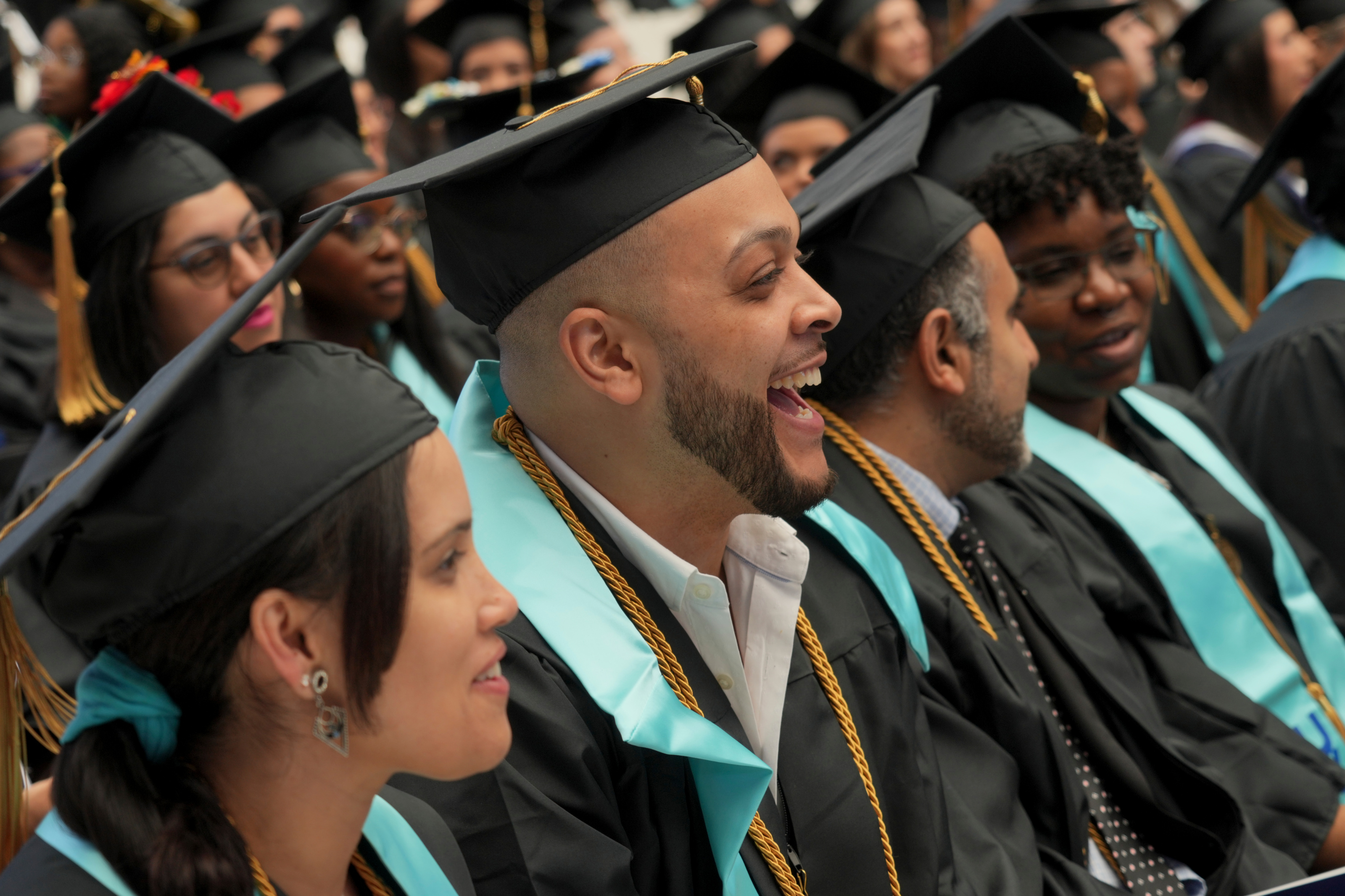 Crowd of graduating students alongside families and friends