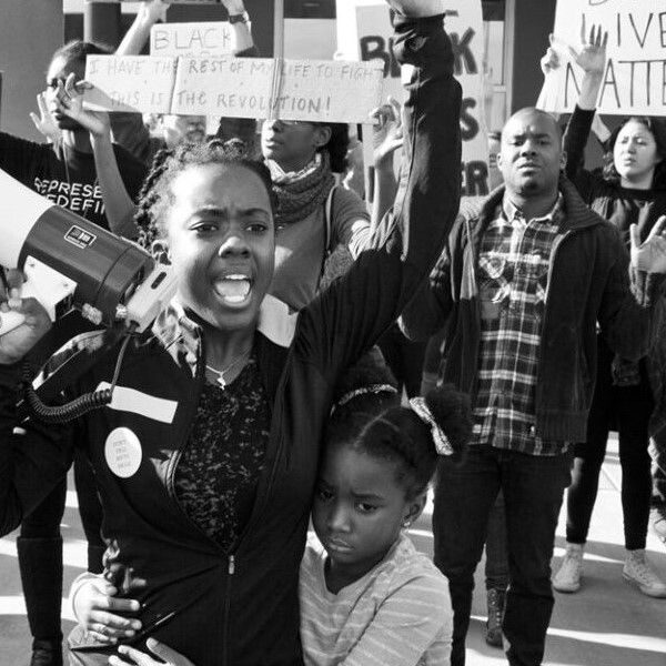 Photo of protesters at a Black Lives Matter rally featuring a mother and child